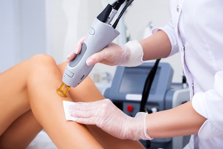 close up of professional using laser hair removal on leg