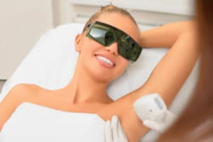 woman wearing protective glasses undergoing laser armpit hair removal