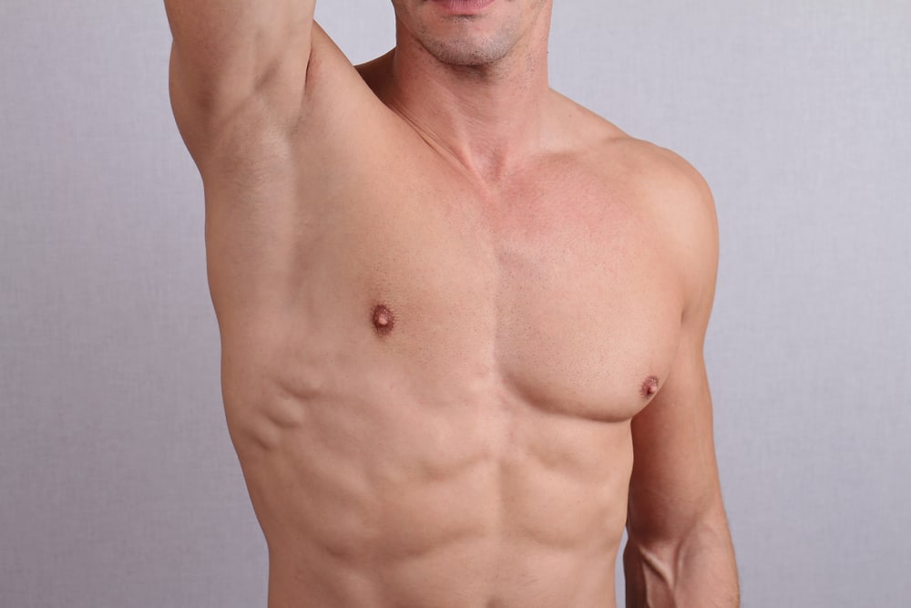 Close up of muscular male torso, chest and armpit hair removal. Male Waxing